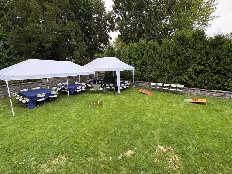 Bongo tents, seating, and optional yard games set up across a backyard